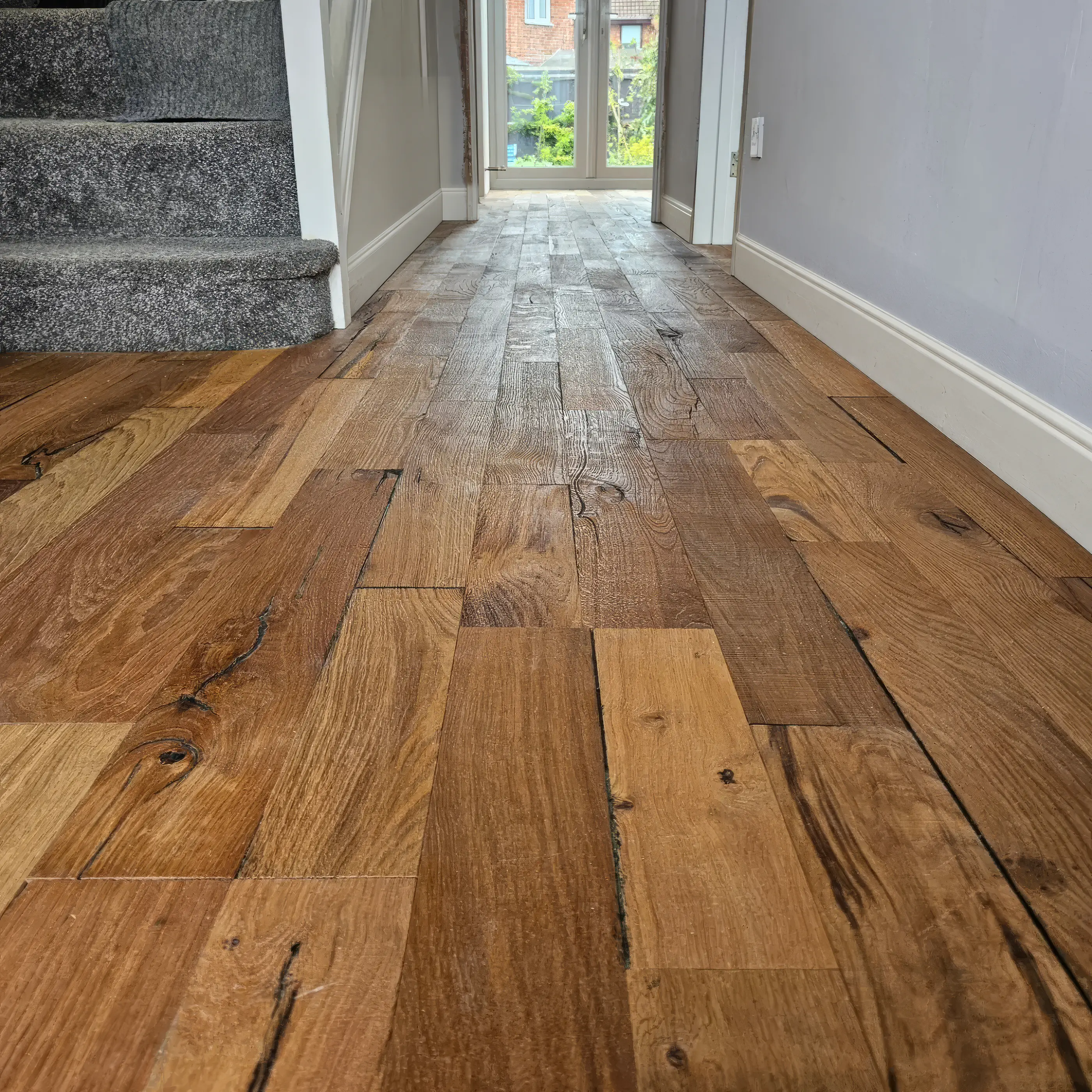 Wide rustic oak floorboards laid by Imran down a hallway